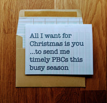Load image into Gallery viewer, Accounting holiday card on ledger-paper background atop a ledger paper lined kraft style envelope.  the card reads "All I want for Christmas is you...to send me timely PBCs this busy season".