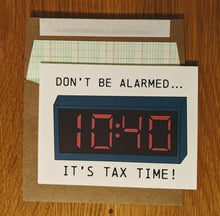 Load image into Gallery viewer, Accounting themed greeting card that says "Don't be alarmed, it's tax time!" with a picture of a digital alarm clock where the time is 1040, sitting atop a ledger paper-lined kraft style envelope.