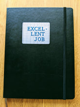 Load image into Gallery viewer, Rectangular sticker with spreadsheet background saying "Excel-lent Job" on top of black Moleskine notebook
