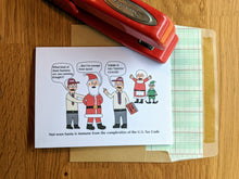 Load image into Gallery viewer, Accounting greeting card with two IRS agents arresting Santa Claus (who claims he is exempt from taxes), while Mrs. Claus and an Elf look on from the background, the second agent says "There is no 'Santa' clause", with the text on the bottom of the card reading "Not even Santa is immune from the complexities of the U.S. Tax Code", atop a ledger paper-lined envelope.