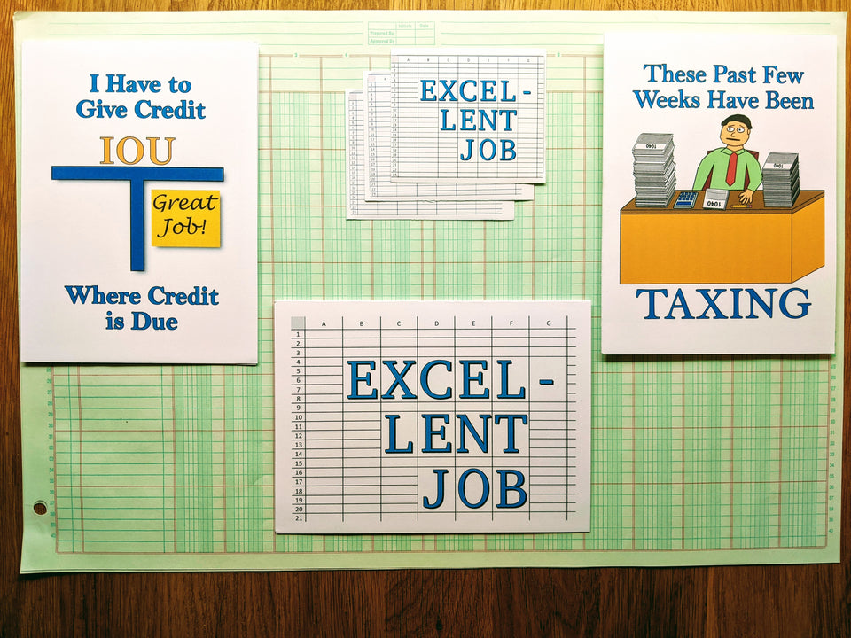 Three busy season related accounting greeting cards and accounting-themed stickers arranged atop a sheet of ledger paper