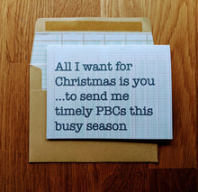 Load image into Gallery viewer, Accounting holiday card on ledger-paper background atop a ledger paper lined kraft style envelope.  the card reads &quot;All I want for Christmas is you...to send me timely PBCs this busy season&quot;.

