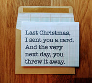 Accounting greeting card with ledger paper background that states Last Christmas I sent you a card, and the very next day, you threw it away. Card is atop a ledger-paper lined kraft style envelope.