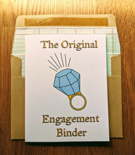 Load image into Gallery viewer, Accounting greeting card atop ledger-paper lined kraft envelope.  The card has an oversized diamond ring in the middle, with writing that states &quot;The Original Engagement Binder&quot;.
