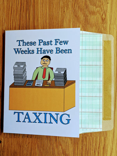 Accounting greeting card with accountant at desk which has from left to right a giant stack of Form 1040, a 10-key calculator, a Form 1040, a pencil, and another large stack of Form 1040 slightly shorter than the first, atop a ledger paper lined envelope.